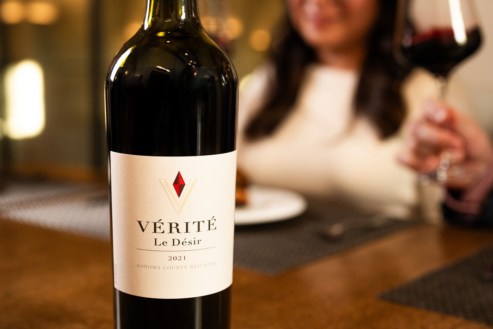 Le Désir bottle at a dining room table